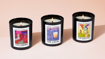 Three candle jars with colorful labels 