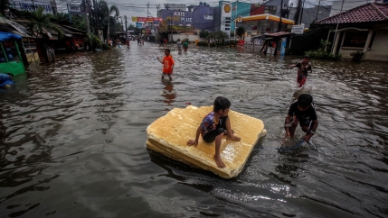 Children play in the floodwaters after heavy rains in Bekasi, near Jakarta, Indonesia, Feb. 25, 2020.