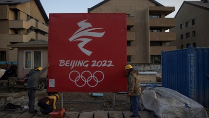 Workers move a sign at the Olympic Village for the 2022 Winter Olympics in the Chongli district of Zhangjiakou, Hebei province, China, Oct. 29, 2020.