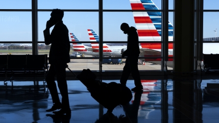 Wearing masks, travelers walk to and from their planes at Ronald Reagan Washington National Airport, Nov. 24, 2020, in Arlington, Virginia, in advance of the Thanksgiving holiday.