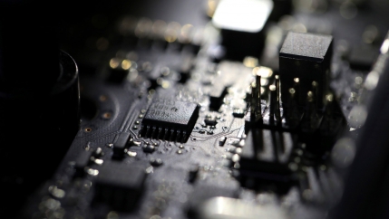 A computer board is shown with computer chips and other technology attached.