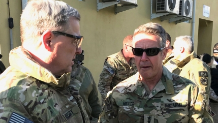 Gen. Mark Milley and Gen. Scott Miller are shown facing each other and wearing military fatigues.