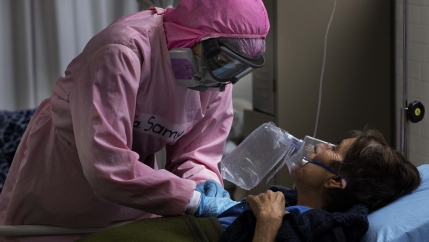 Dressed in protective gear to curb the spread of the new coronavirus, a medical worker massages a patient, at a military hospital set up to take care of COVID-19 patients.