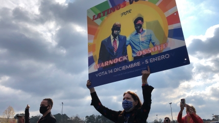 A supporter holds up a large sign during a rally. 