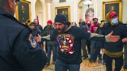 Trump supporters gesture to US Capitol Police in the hallway outside of the Senate chamber at the Capitol in Washington, Jan. 6, 2021. 