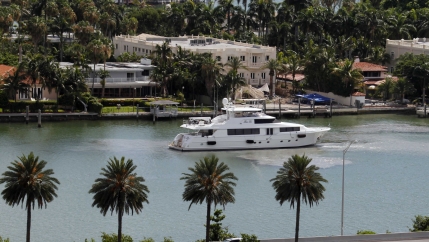 A yacht maneuvers near homes on Palm Island