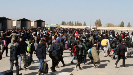A large group of refugees walk through an Afghanistan-Iran border point. 