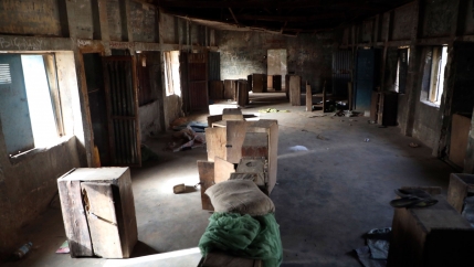 An empty room is shown with boxes strewn around and bright light pouring in from the open windows.