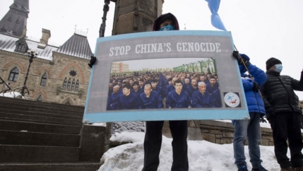 A protester is shown holding a large sign the has the words, 