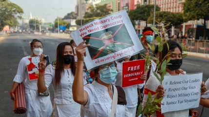 A demonstrator displays a picture of the defaced image of the commander in chief, Senior Gen. Min Aung Hlaing, also chairman of the State Administrative Council to protest against the military coup in Yangon, Myanmar, Feb. 17, 2021. The UN expert on human