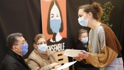 An administrative worker explains to people how to fill up the national vaccination certificate in a vaccination center in Strasbourg, France, March 18, 2021. France is set to announce new coronavirus restrictions on Thursday, including a potential lockdo