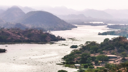 A large scenic river with sloping mountains on either side.