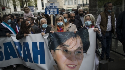 Protesters carry a banner with Sarah Halimi's face and name printed on it in a protest over a court's decision not to try her killer.