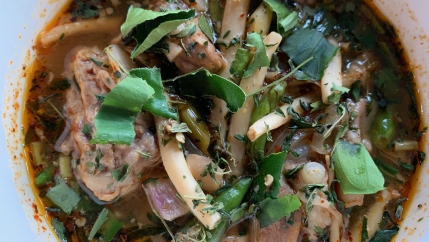 Sour pork soup flecked with cannabis leaves, served at Baan Lao Ruang restaurant in Thailand.