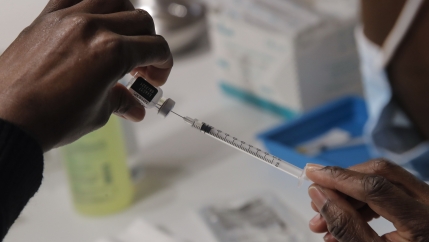 A member of the Paris Fire Brigade prepares a syringe with the Pfizer COVID-19 vaccine