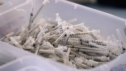 A photo of a bin of used syringes inside a trailer. 