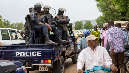 A crowd of people are shown next to a pickup truck with 