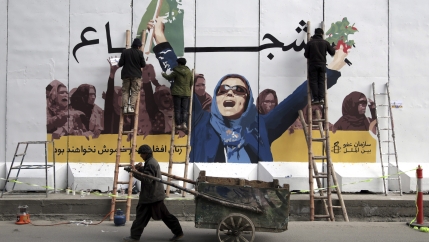 Woman in blue outfit holding up her arms