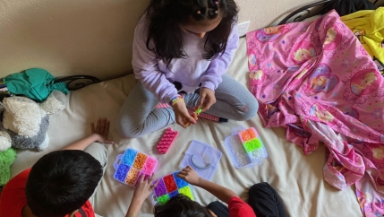 Dinora Hernandez’s three children make bracelets at home in Oakland, California. Every Tuesday, Hernandez heads to a local food bank, assistance that allows her to wire cash to family in El Salvador.