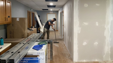 A man sweeps the floor in a church being turned into an apartment