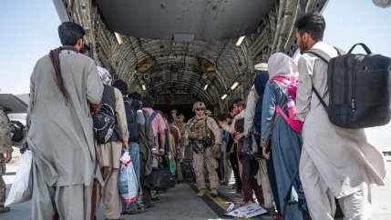In this Aug. 21, 2021, image provided by the U.S. Air Force, US Airmen and U.S. Marines guide evacuees aboard a US Air Force C-17 Globemaster III in support of the Afghanistan evacuation at Hamid Karzai International Airport in Kabul, Afghanistan. 