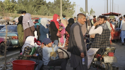 Hundreds of people gather near an evacuation control checkpoint during ongoing evacuations at Hamid Karzai International Airport, in Kabul.