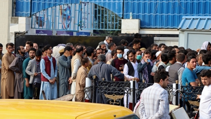 Afghans wait in long lines for hours to try to withdraw money, in front of a Bank in Kabul, Afghanistan