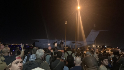Crowd at night gathered around a Luftwaffe transport plane