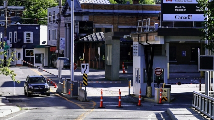 A vehicle in Canada waits for a gate to rise while crossing into Derby Line, Vt. from Stanstead, Quebec, July 11, 2018.