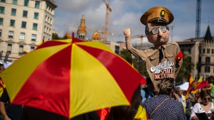 A demonstrator holds a paper doll representing regional Catalan President Quim Torra, as they celebrate a holiday known as