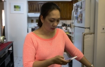 Close-up of woman in kitchen, looking at phone