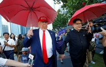 Men impersonating North Korean leader Kim Jong-un and US President Donald Trump meet at Merlion Park in Singapore, June 8, 2018.