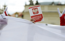 A demonstrator holds a copy of the Polish Constitution