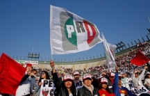 A crowd is gathered under a flag reading PRI in green, white and red.