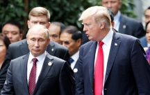 US President Donald Trump and Russian President Vladimir Putin are seen walking side-by-side surrounded by other officials.