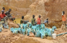 Local miners fill bags with gravel extracted from holes dug by Chinese mining machines in Ngoe Ngoe, Cameroon, Feb. 15, 2018.