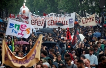 French civil servants and students carry labor union flags and banners as they march in protest during a national day of strikes by public sector workers, in Paris, France, May 22
