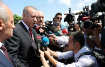 A crowd of reporters surrounds Turkish President Tayyip Erdoğan