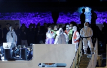 people in white protective suits on a boat