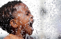 A close-up photo of a boy playing in a fountain in Brussels, Belgium.