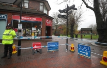 A police officer is shown standing to the left of the photograph, wearing a fluorescent jacket guards a cordoned off area where former Russian intelligence officer Sergei Skripal and his daughter Yulia were found poisoned.