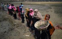 rohingya women lined up, carrying large baskets