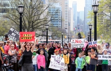 People hold signs reading