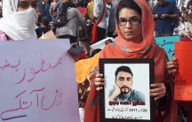 Pashtun women in Pakistan hold posters of their missing family members