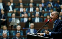 Turkish President Tayyip Erdoğan is shown at a podium addresses members of parliament in Ankara, Turkey.