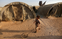 a child plays at a camp in Idlib, Syria