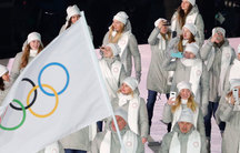 People dressed in white carry the Olympic flag instead of the Russian flag. 