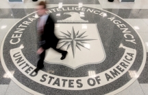 A man's image is blurred as he walks across a giant marble seal in the floor of the CIA headquarters in Langley, Virginia.