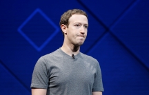 Facebook's Mark Zuckerberg standing on a stage wearing a grey t-shirt, in San Jose, Calif., 2017. 