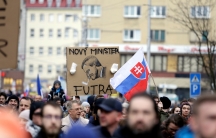 People hold up a cartoon of the new Slovak Prime Minister Peter Pellegrini during a march in Slovakia